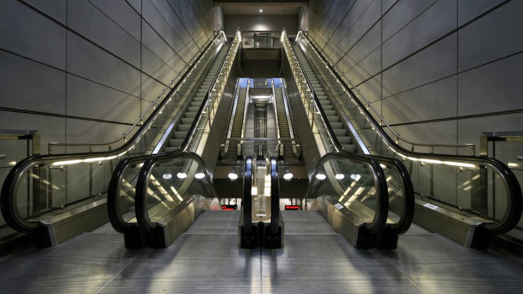 Modern indoor escalators arranged symmetrically inside a contemporary building.