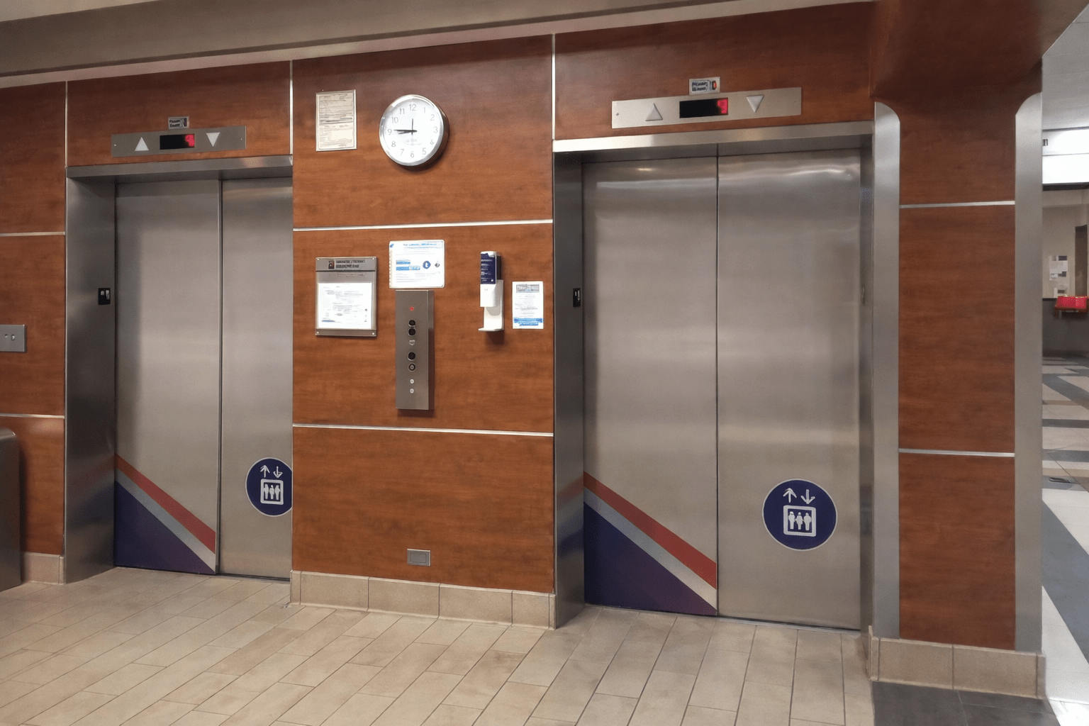 Two modern passenger elevators installed side by side in a commercial building lobby, featuring sleek doors and clear floor indicators for smooth and accessible vertical transportation.