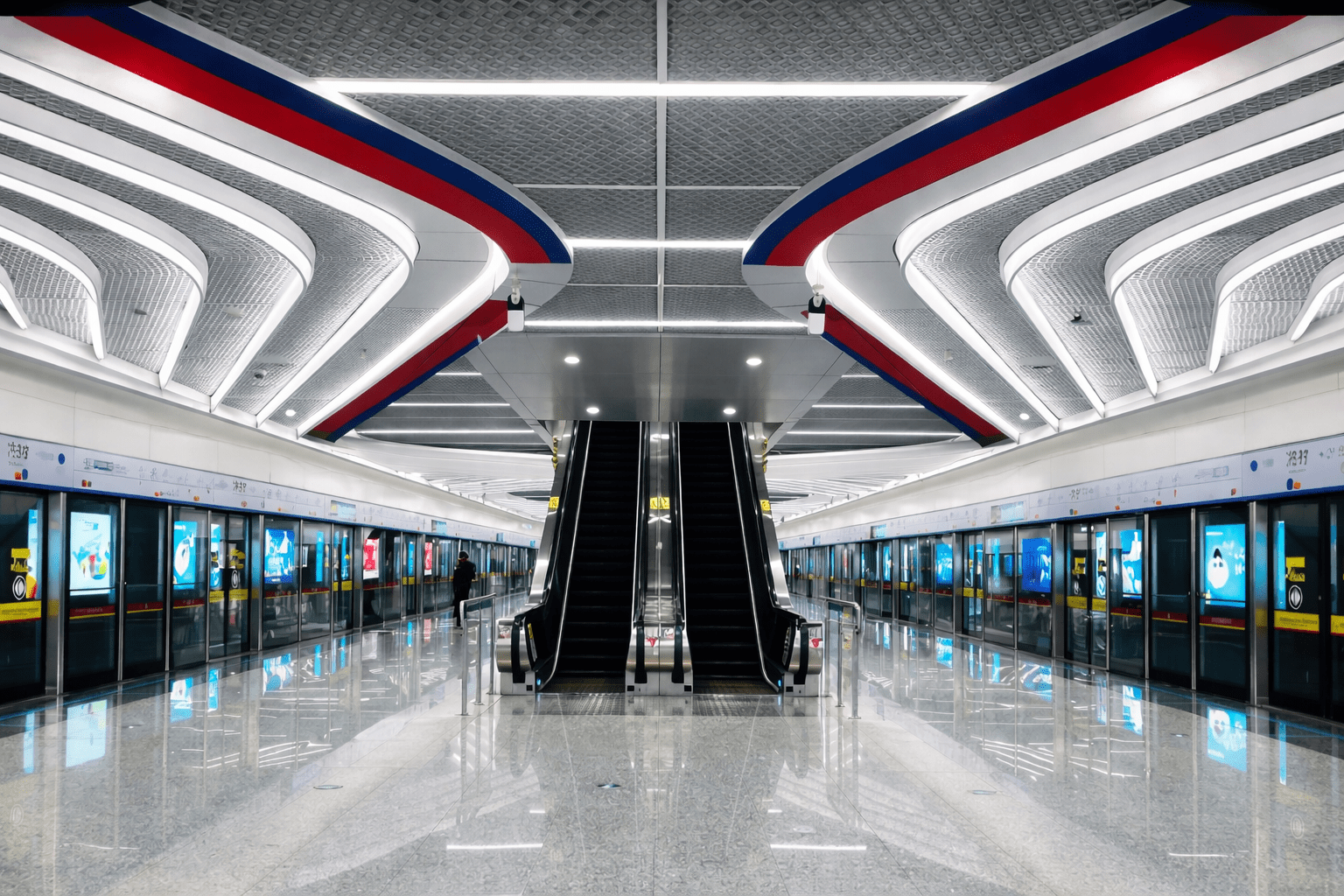 Modern transit station interior featuring symmetrical escalators, wide platforms, and contemporary lighting design.